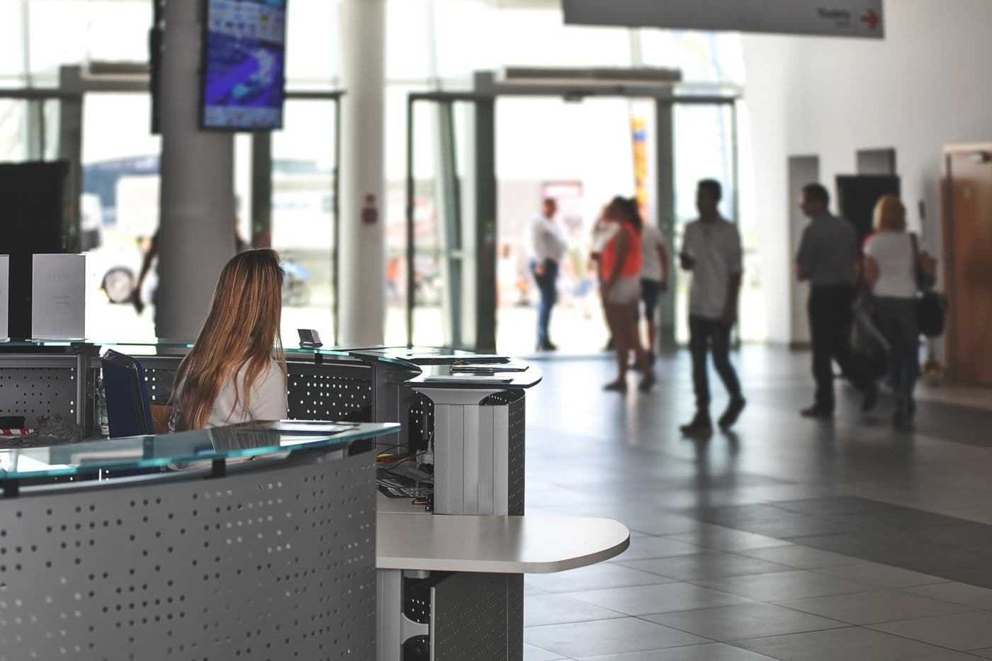 Modern office reception area with employees and visitors